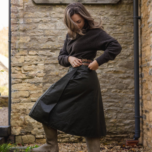 Woman wearing her handcrafted habit while altering her buckles in countryside.