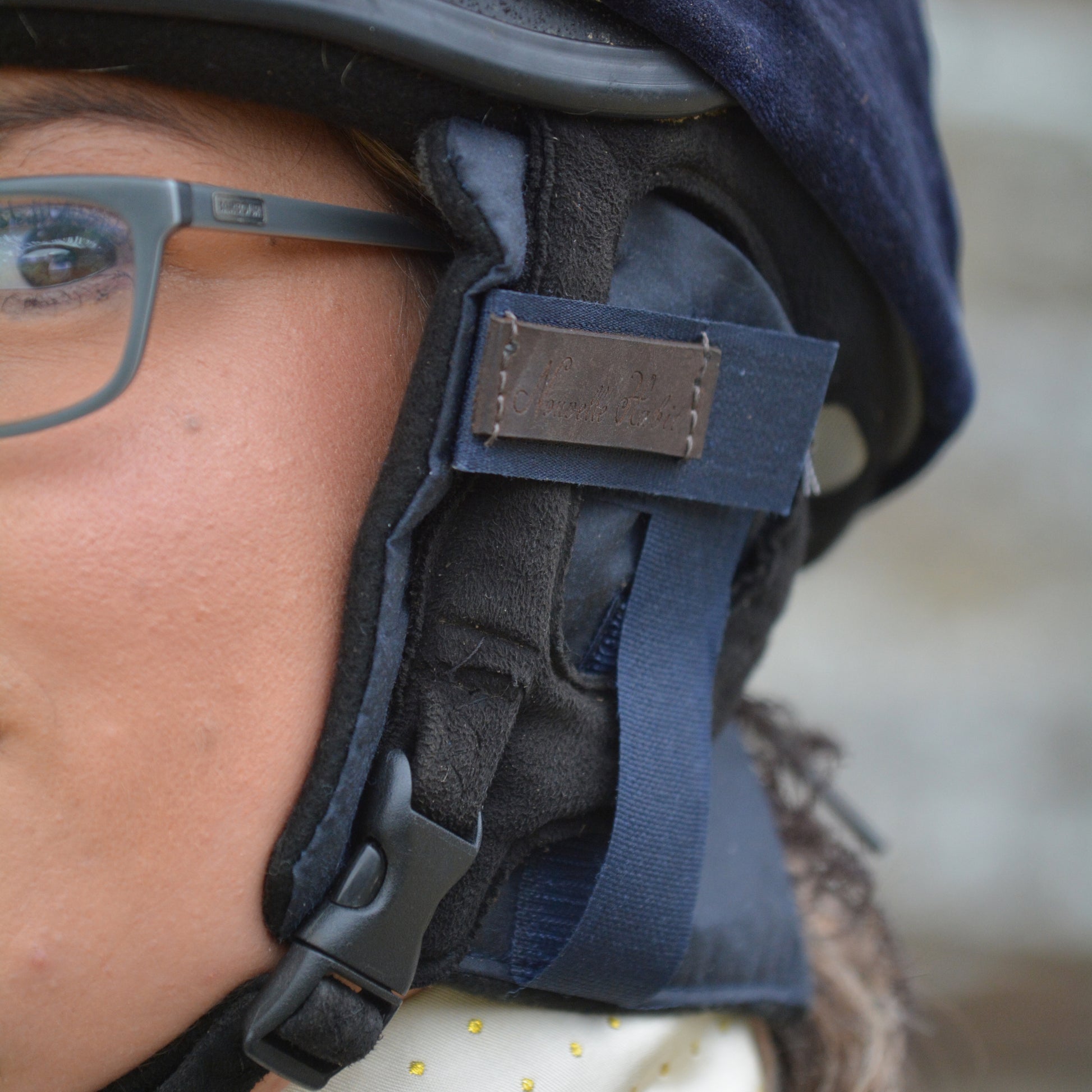 Close up of our navy blue ear warmers fitted into a riding hat.