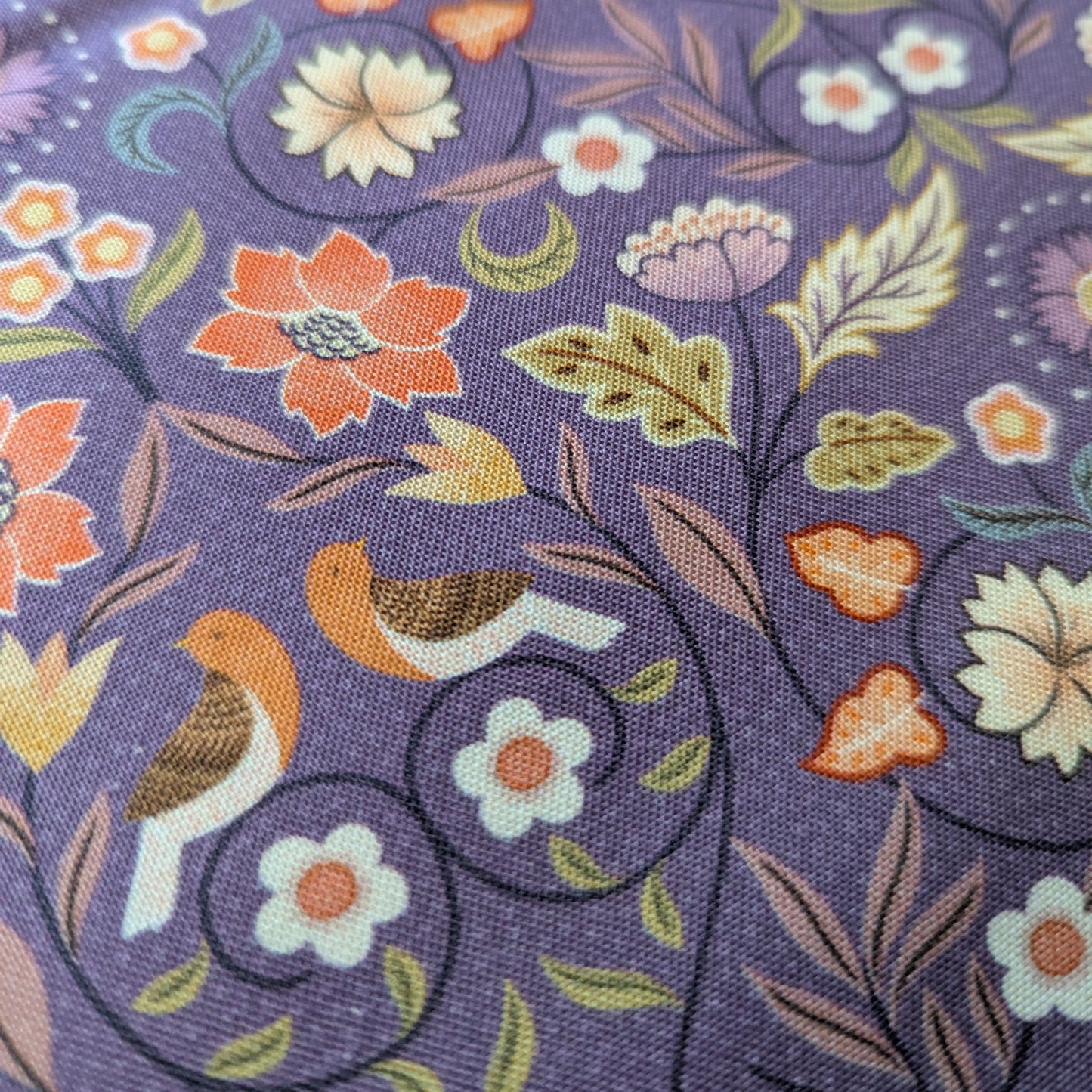 Close up of the hidden Robbins in this purple Arts and Crafts inspired design fabric.