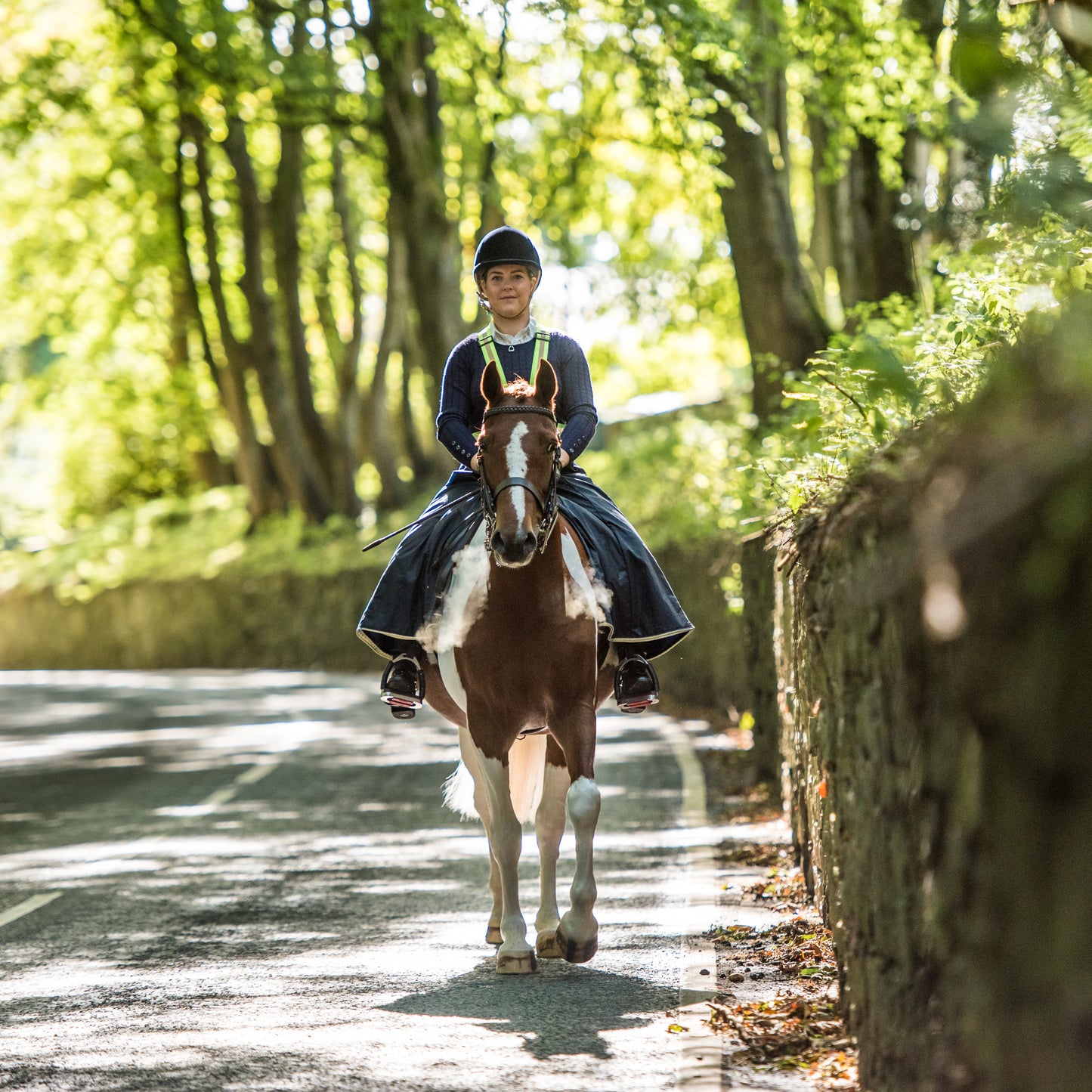 Woman wearing handcrafted riding habit on a country road in the cold air causing misty steam to come out of the horses nostrials.