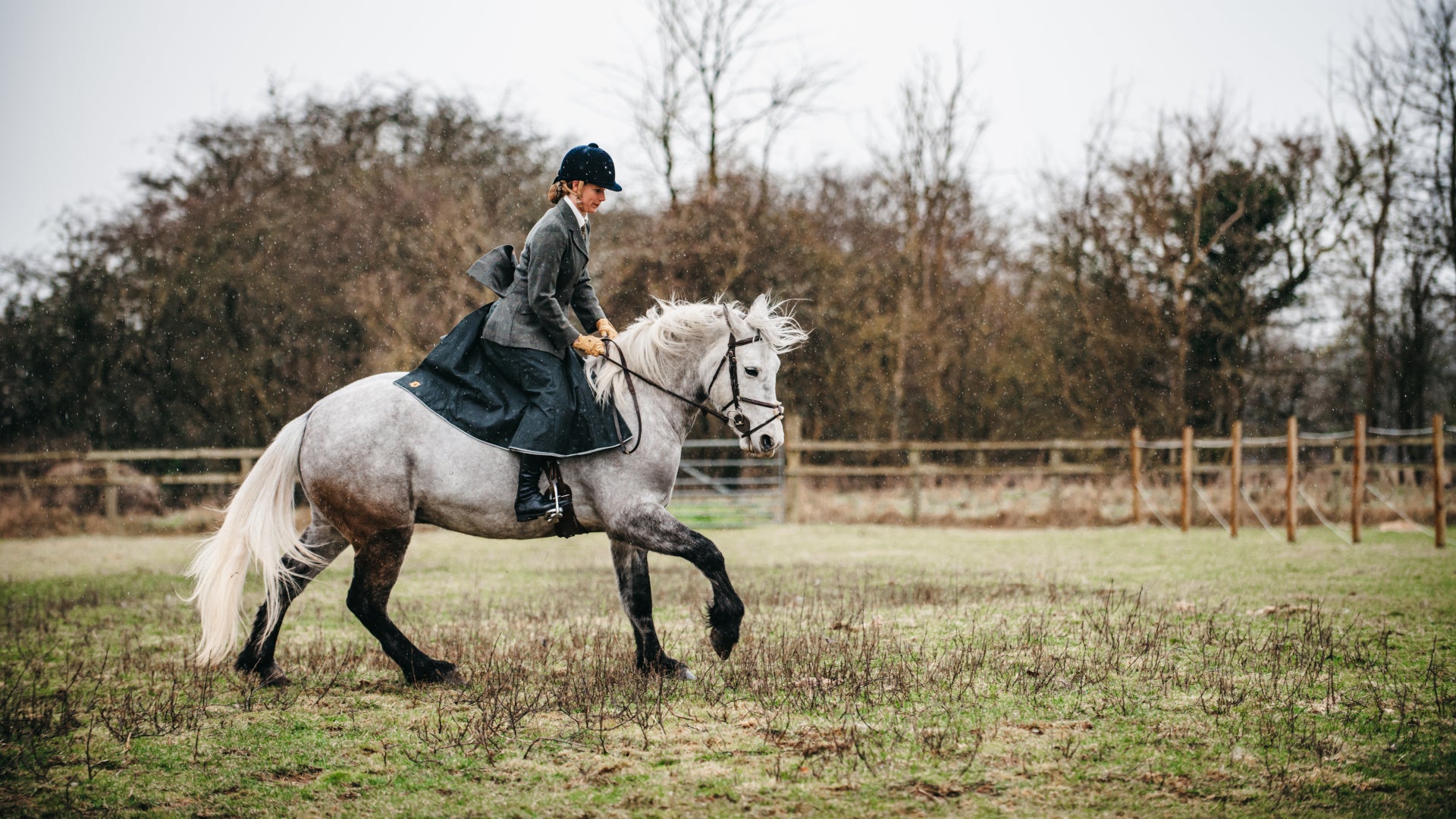 British-made waterproof riding skirt worn on a cantering horse in the rain