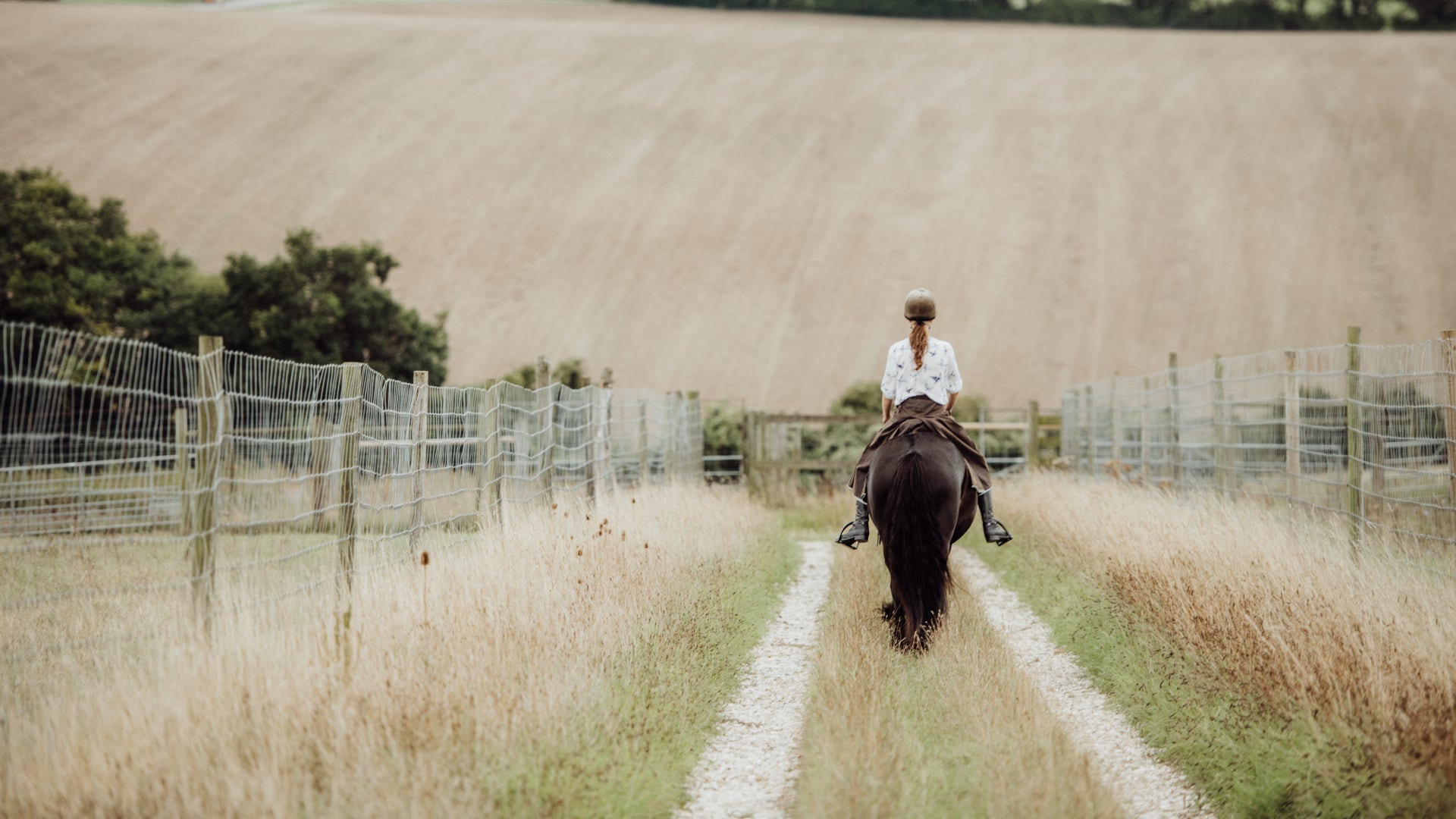 Hand crafted, waterproof riding skirt in Brown. Worn while riding down a counrty track.