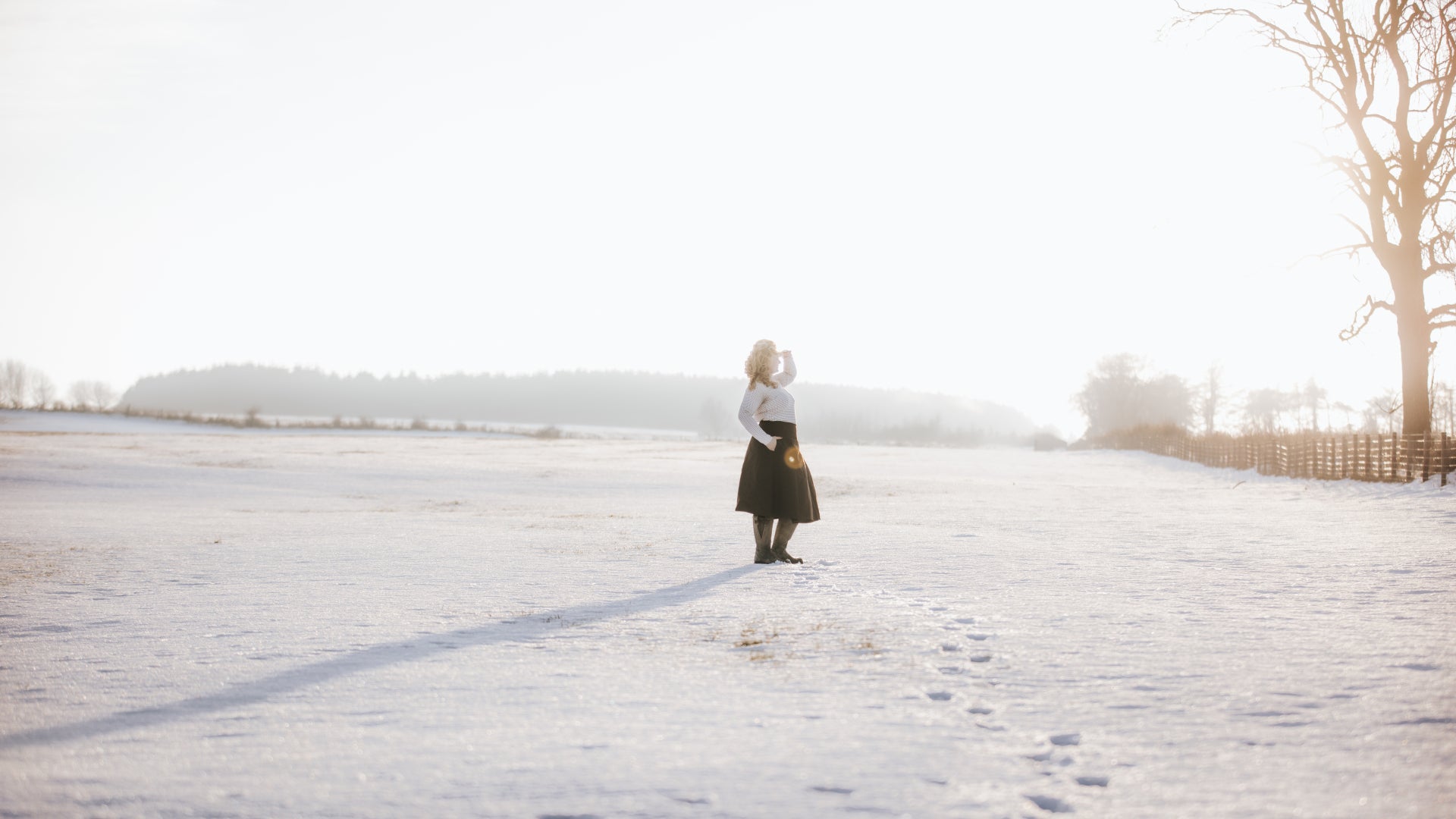British-made waterproof habit stood in a snow coverd field, with low golden light.